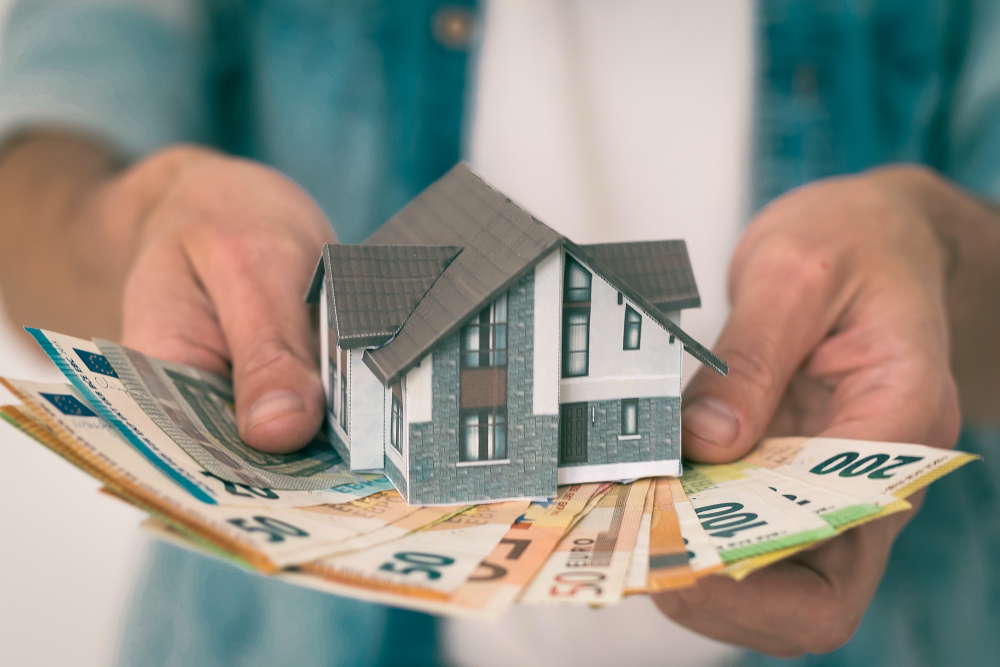 Hausmodell auf Euro-Scheinen – Immobilienverkauf mit DESEO Immobilien Mannheim